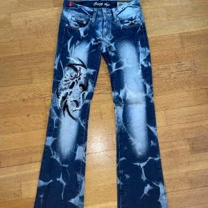 crazy age jeans - Mörk blå crazy age jeans low waist med vit och svart design på bena nästan aldrig använd. Storlek eur 34. Har inga slitningar på jeansen 