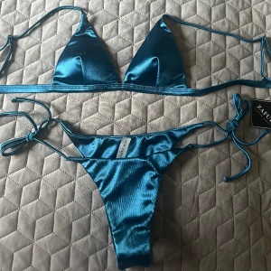 Bikini - Skitsnygg bikini i satin. Helt oanvänd med prislappen kvar, säljer pga för liten storlek.