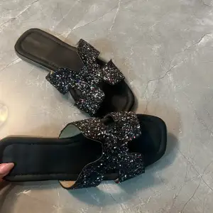 Säljer dessa snygga Hermés-inspirerade sandaler med glitter på😍  Använda men fortfarande i väldigt fint skick!  Storlek 37 men passar även 38!!  