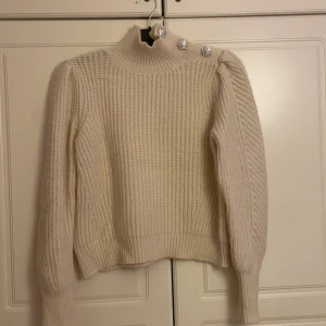 Stickad tröja - Super mjuk och Elegant stickad tröja tröja med silverknappar i krämvit färg , köpt från vero moda i storlek S , tröjan säljs för 120 kr