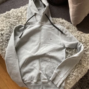 JLindeberg hoodie - Hoodie i bra skick.  Storlek S J Lindeberg  Ett litet hål längst ner på ärmen som lätt går att sy ihop så det inte syns. 