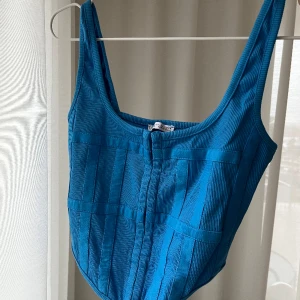 Blå topp - Korsettliknande topp i den finaste blå färgen, använd 1 gång så verkligen nyskick! Passar någon med mindre byst. Strl L men mer som S/M. 