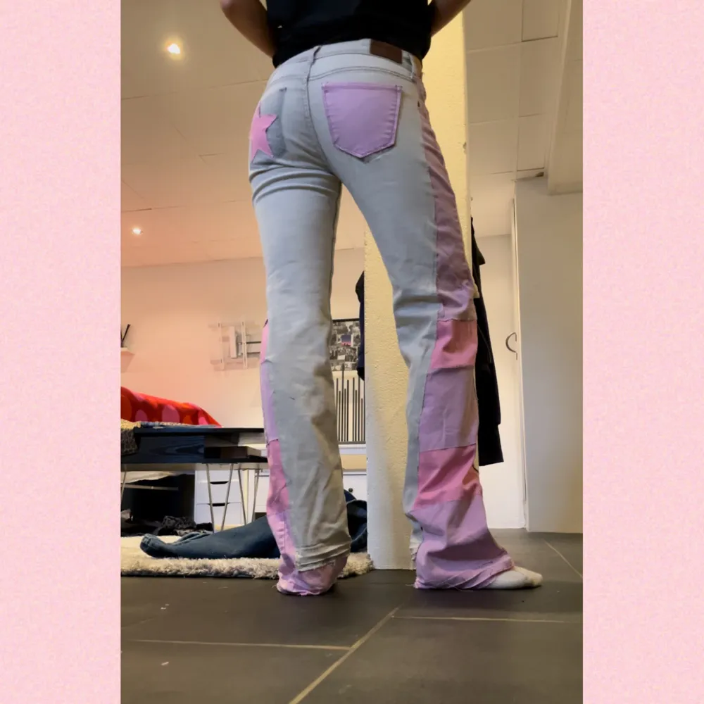 Säljer mina egengjorda jeans i ljusgrå med rosa och lila plus en stjärna ⭐️. Mina första, därav billigt pris. Midja: 39cm Innerben: 84cm💜🩷💜🩷. Jeans & Byxor.