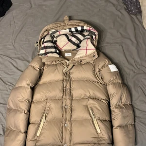 Burberry jacka - Säljer denna jacka då jag har växt ur den. Skicket är fortfarande bra då den mest har användas vid fina tillfällen. Det är storlek M på jackan.