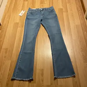 (2) lågmidjade bootcut jeans som är ljusblåa, med fransar i botten, jätte stretchiga, helt nya med lappar kvar. Innerbenslängd: 78cm, midjemått rakt över: 35cm🩵