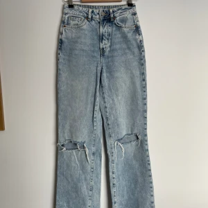 Jeans - Ljusblåa vida/raka jeans med hål på knäna. Använda men ändå i bra skick. Storlek 25 i midjan, köpta på bikbok. DM för fler bilder 