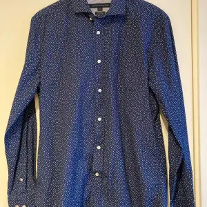 Mörkblå skjorta från Tommy Hilfiger.  Längd armhåla till armhåla ca 53 cm.  Längd ca 74 cm.  #tommyhilfiger #hilfiger #shirt #skjorta #märkeskläder #skjorta #brandedclothing #markoweubrania #märkesskjorta