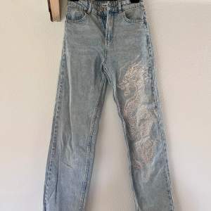 Ljusblåa jeans i storlek XS. Hollander dessa byxorna jättemycket men har bytt stil sedan jag köpte dem. Dem är långa i benen vilket är perfekt för alla som är långa och de har ett stort coolt drak tryck på ena benet. Jag är öppen för pris förslag. 