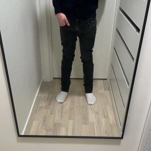 Svarta Nudie Jeans - Just nu säljer jag dessa feta Nudie jeans i en svart/grå tvätt. Storleken på jeansen är 31/32 och passformen är Tape Ted. Modellen på bilden är 170cm, 60kg. Vid frågor och funderingar är det bara att skriva.