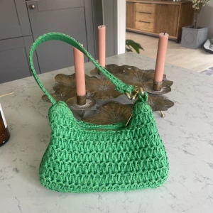Axelväska  - Säljer min otroligt fina och somriga axelväska från HM. Använd ett fåtal gånger. Grön med guldiga detaljer💚