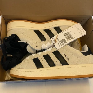Nya Adidas Campus 00s -storlek 36 2/3 - Adidas Originals Campus 00 OBS Storlek: 36 2/3 Färg: Crystal White / Core Black / Off White Ingår både svarta och vita skosnören.  Nya och oanvända. Ligger kvar i kartong.