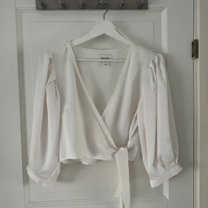 Vit topp - Vit lite kortare topp med knytning från Monki. Strl 38. Köparen står för frakten 