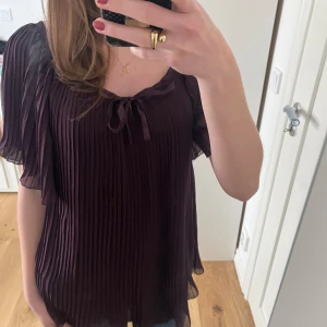 Fin mörklila blus med volang från Vero Moda! Knyten överst, typ lite off-shoulder 💜 - Fin mörklila chiffongblus med veck!! Från Vero Moda. Volang längst kanten och ärmarna. 💜Knytband överst, lite off-shoulder, beror på hur man knyter. Perfekt skick. 