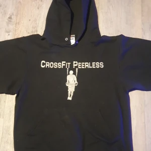 Svart crossfit hoodie - Ganska bra skick förutom att den är lite nopprig. Texten ska se riven ut. Hoodien är ganska tjock och varm då man kanske behöver träna i kylan eller ha något varmt över vintern. Framsidan är en fungeramde ficka vid magen :)