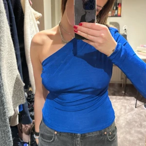 One-shoulder blå topp - Säljer nu min superfina one-shoulder topp från Gina tricot i superfint skick. Ingen aning vad jag köpte den för men säljer för 100kr!!