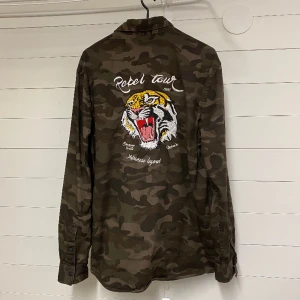 Tuff skjorta av märket Bershka - Bershka långärmad skjorta med tufft tryck på baksidan. Strl. M Frakt tillkommer 