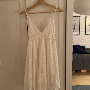 Kort sommarklänning - En jättefin vit kort sommarklänning, perfekt till sommaren. Väldigt bra skick, aldrig använd endast provat den. Frakt tillkommer.