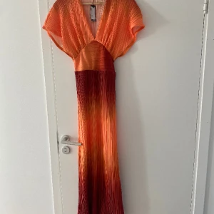 Orange längre klänning  - Klänning är bara prövad, aldirg använd 