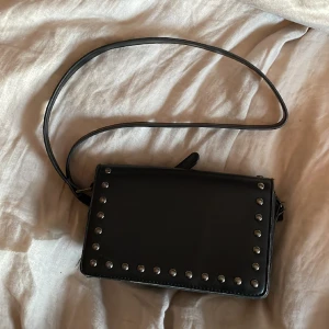 Väska - Säljer min väska. Den är rätt rymlig, får plats med mycket i. Vet ej vilket märke den är köpte den i Kroatien. Den är väl använd men fortfarande jätte fin. Den har reglerbart band så men kan välja hur lång/kort man vill ha den😊