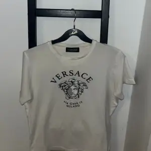 Säljer en vit Versace T-Shirt. Köp på NK i Gbg för 2200kr.  Storlek 12y/152 Säljer för 950kr Skick 8/10 Dm för mer information.