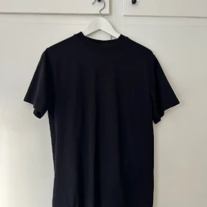 T-shirt från Eytys - T-shirt i modellen Purple Velvet, Smith, som tyvärr har inte har kommit till användning. Finns inget att anmärka på. Den är oversized och längre i modellen.   Storlek: XXS Material: 100% bomull