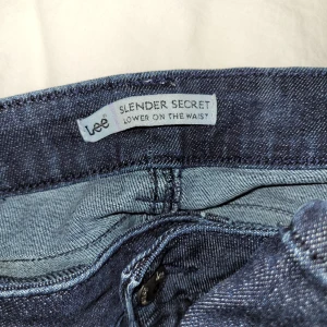 Lee Lågmidjade jeans - Fina Lee jeans, köpta på beond retro i stockholm. För stora för mig, därför säljer jag. De är mörkblå i färgen och har stenar på fickorna