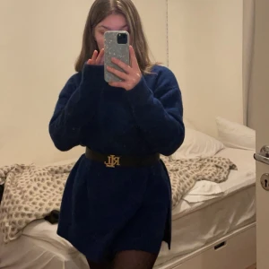 Mörkblå stickad tröja - En mörkblå stickad tröja/klänning med långa ärmar och ribbstickade muddar vid ärmslut och nederkant. 