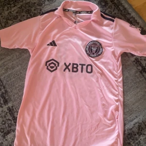 miami rosa tröja - Köpt i Libanon. Lite tight hade inte rekommenderat om du har stora axlar eller bröst.