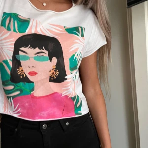 T-shirt med tryck - Så snygg croppad t-shirt från Pull & Bear med färgglatt tryck, som är i jättefint skick! Storlek S. Boxig passform och avklippt vid halsringningen, ärmsluten och i nederkant. 💘