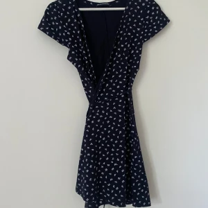 Klänning - Blommig klänning från Brandy Melville med band som knyts i midjan Storlek onesize 