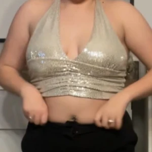 En silvrig topp som man knyter där bak - Säljer en silvrig/guldig topp som man knyter med två snören bakom nacken. Köpt av en annan här på plick. Knappt använd🩷