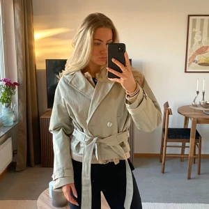 Kort trenchcoat  - Beige kort trenchcoat från Lindex, köpt förra året för 1000kr från Lindex! Jättefin och bra skick men vill hellre ha en lång. 