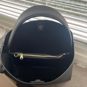 Arket väska ”axelremsväska i läder” - Mellanstor axelremsväska men tillhörande längre band. Super fin och stilren vardagsväska. Inte mer än ett år gammal och i fint skick, lite små skavanker på handtaget men inget synligt. ( Orginalpris 1990kr)