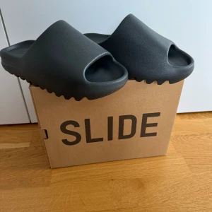 Yeezy Slides Dark Onyx storlek 42 - Säljer ett par Yeezy Slides Dark Onyx då jag råkade klicka hem 2 par vid droppet 7/3-24.  Storlek 42  Finns att hämta i centrala Örnsköldsvik eller skickas på köparens bekostnad.   1100kr eller bud