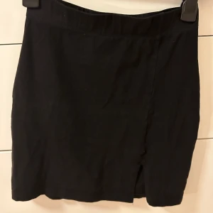 Svart minikjol med slit - Svart minikjol med slits  Använd vid ett par tillfällen Kommer inte till användning längre