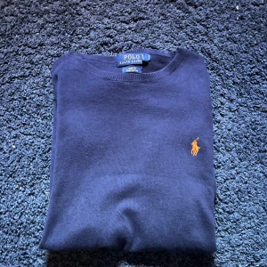 Polo Ralph lauren tröja - Hej! Jag säljer min snygga polo Ralph lauren tröja. Den är bra i passformen och har inte hål eller defekter. Det jag stör mig lite på är att min t-shrit som jag har under syns där vid halsen då kragen är ganska långt ner. Skriv till mig minsta lilla.