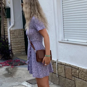 Sommarklänning  - En lila/blommig sommarklänning från pull and bear. Använd en gång under midsommar! Fint skick! 