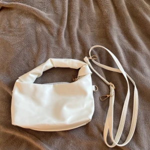 Vit väska  - Vit liten handväska, band ingår💗 Aldrig använd.