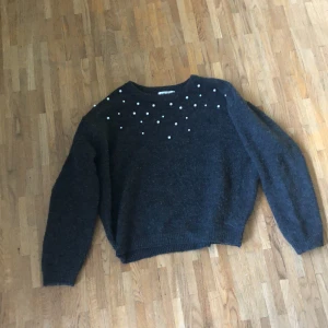 Grå stickad tröja med pärlor - Säljer denna stickade tröja från H&M. Använd några fåtal gånger.