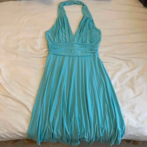 Baby blå / turkos halterneck klänning - Babyblå/turkos, halterneck klänning, slutar några cm ovanför knät. Vring, bar rygg, volanger nedtill. Superfin en av mina favoriter.