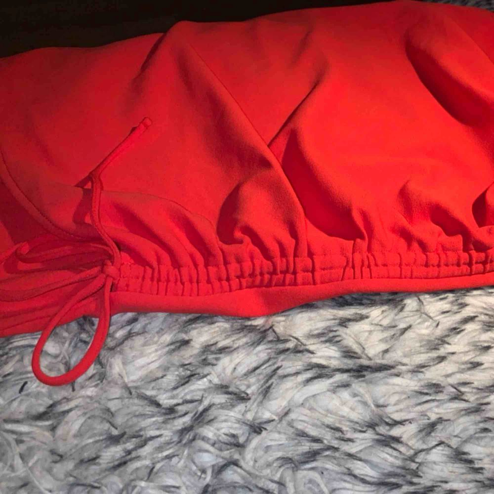 Röd, tight klänning från H&M med spaghetti straps och rysch på sidan. . Klänningar.