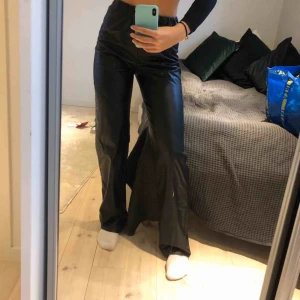  - Svarta utsvängda läderbyxor (fuskläder) med resor midjan. Passar för oss som är lite längre (jag är 176) möts upp i Stockholm eller så står köpare för frakten ☺️