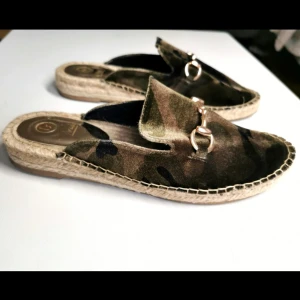 Loafers i camouflage - Jättesnygga loafers i camouflagemönster. Sammet, med guldsmycke. Endast användna 1 gång. Strl.39