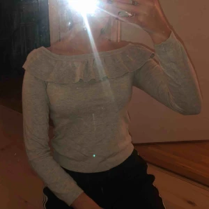  - En super mjuk o skön tröja med volanger upp till, tröjan är lite off shoulder o är i färgen beige. Tröjan är använd men ser ut som nyskick.