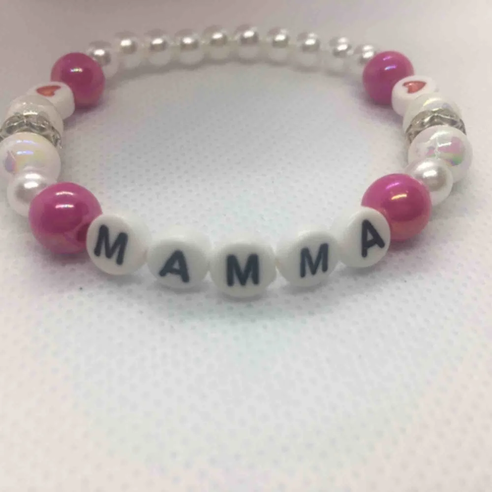 Armband ”MAMMA” kärlek   Fin armband i vit och rosa pärlor.  Handgjorda med elastiktråd och passar till alla handleder. Storlek : 17-18 cm. Accessoarer.