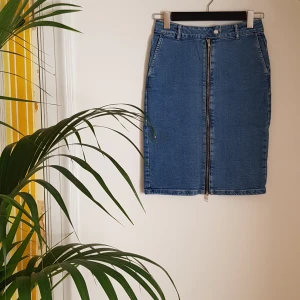 Jeanskjol, Only, stl 36 - Knälång jeanskjol från Only med dragkedja fram och slits baktill. Insydd i svanken för bättre passform. Stl 36. Bomull/elastan. Frakt tillkommer.