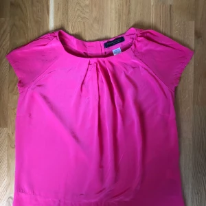 Rosa Topp i silke - Fin mörkrosa topp i 100% silke från Madame A Paris. Inköpt från La Redoute. Oanvänd. Storlek 40 och passar 36-40.