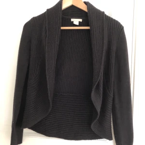 Svart stickad kofta - En mysig kofta med mycket bra passform. Det är spegeln som är smutsig och inte tröjan! Koftan kommer ifrån H&M och är endast använd fåtal gånger. Stl XS