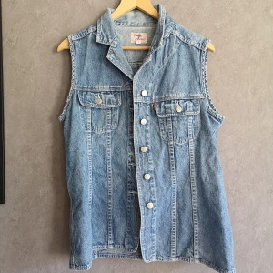 Vintage jeansväst  - Vintage jeansväst märkt 44. Är som en L typ. Fint skick tkr jag. L 72cm Äh-äh typ 51cm knäppt  80kr pp 63kr spårbart