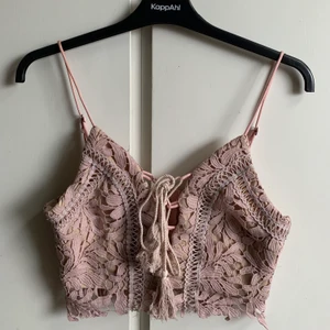Crop Top - En rosa topp från Dennis M. Jag har enbart testat den på men aldrig använt. Snörning frame med två toffsar samt fint spetsmaterial på tröjan. 